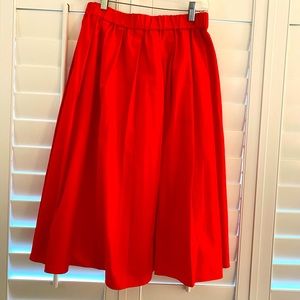 Red/orange pleated skirt.